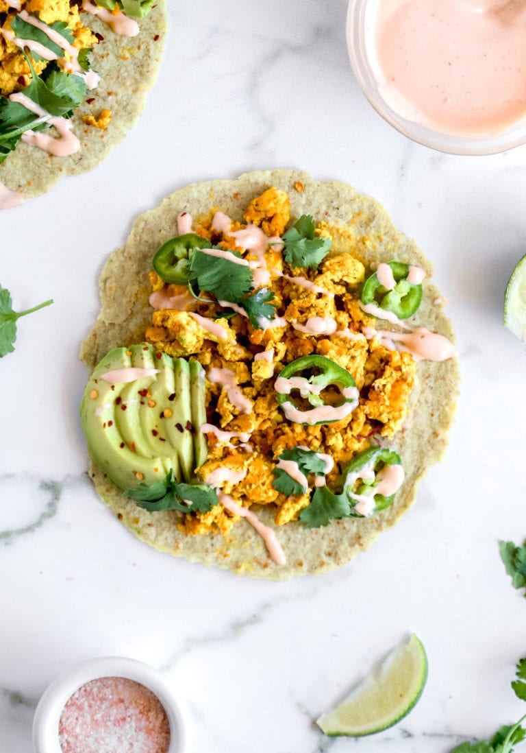 Top down view of gluten-free vegan breakfast tacos on white background.