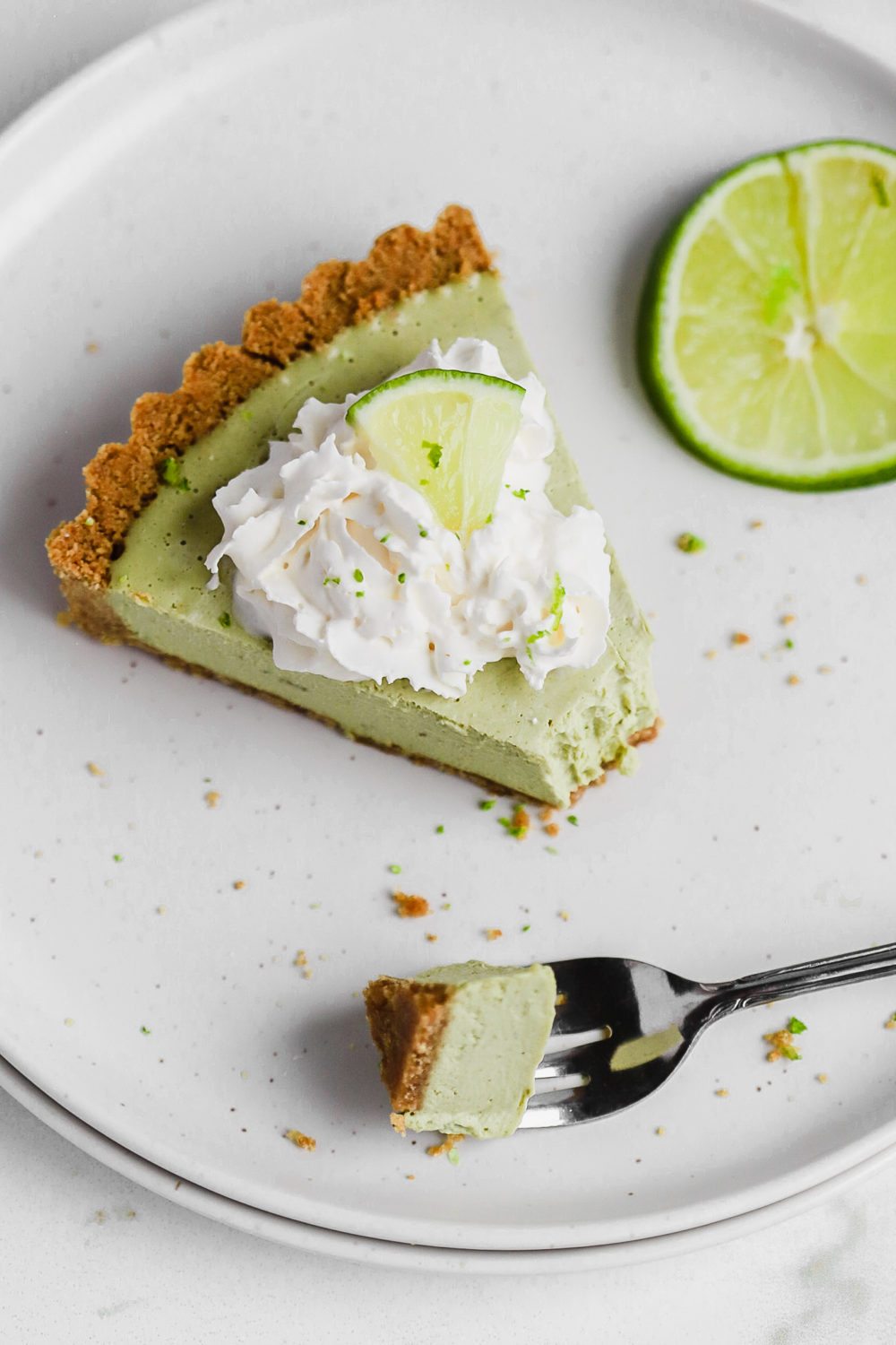 top down view of a vegan pie recipe with whip cream and a lime wedge on top