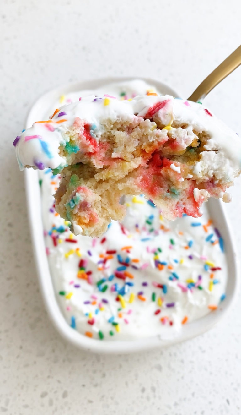 top view of spoon of birthday cake baked oats and ceramic white dish