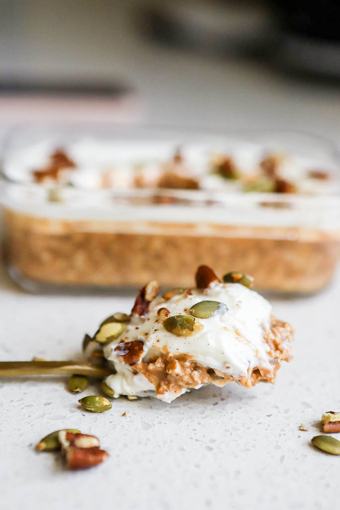 a spoonful of pumpkin cheesecake overnight oats with white chocolate topping 