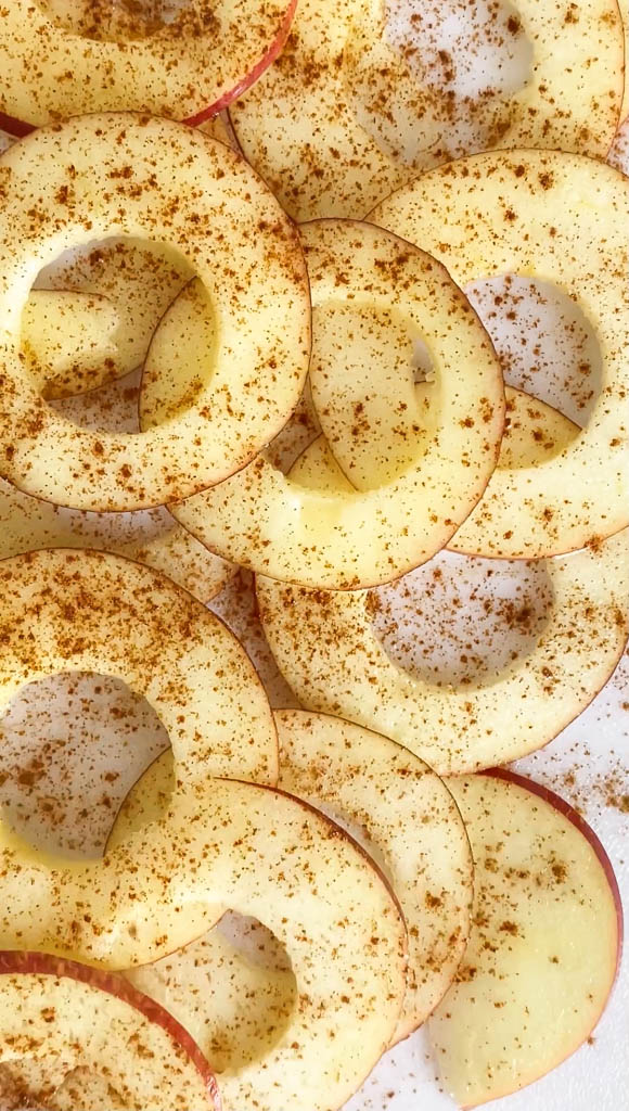 Top down view of raw apples with coconut oil and cinnamon on a plate.