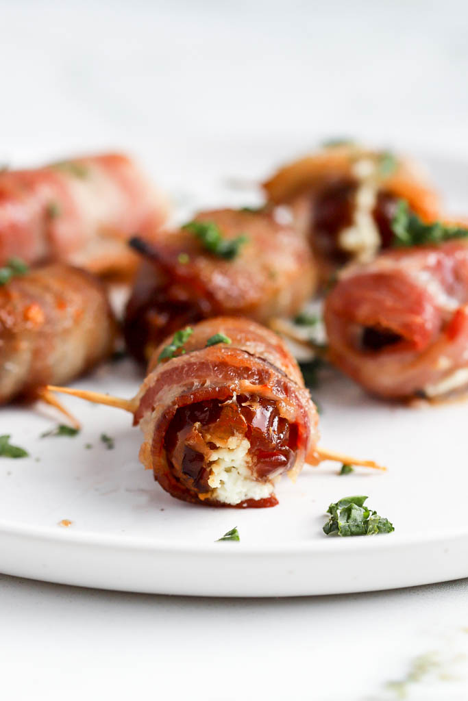 bacon wrapped dates on white plate