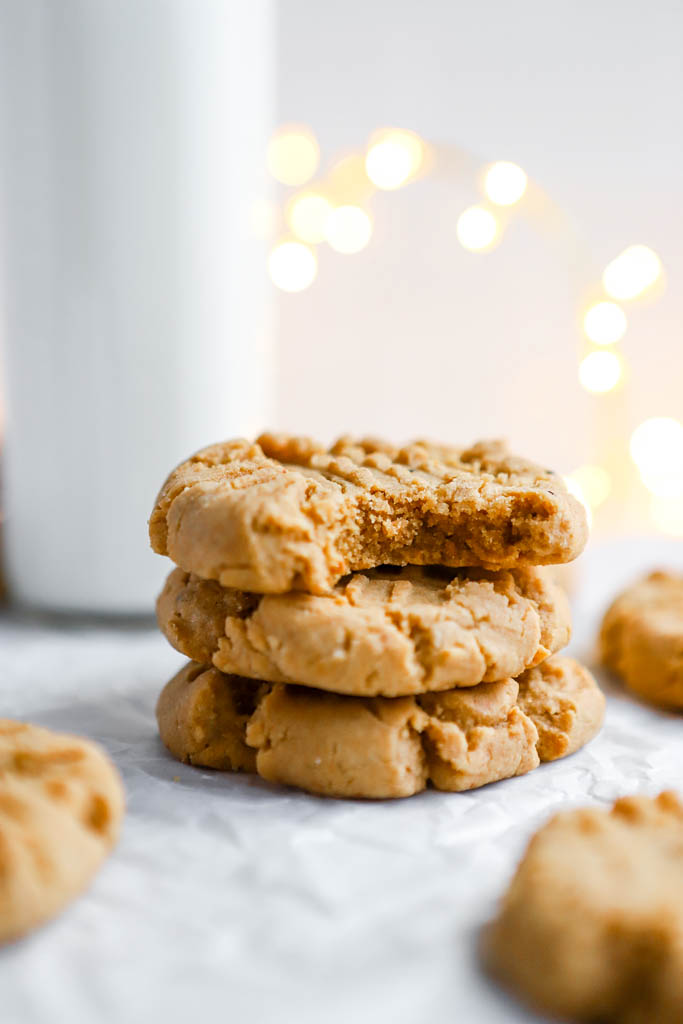 gluten-free peanut butter cookies on parchment paper and a glass of milk