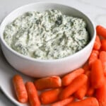 Knorr spinach dip recipe in a white bowl with carrots on the side