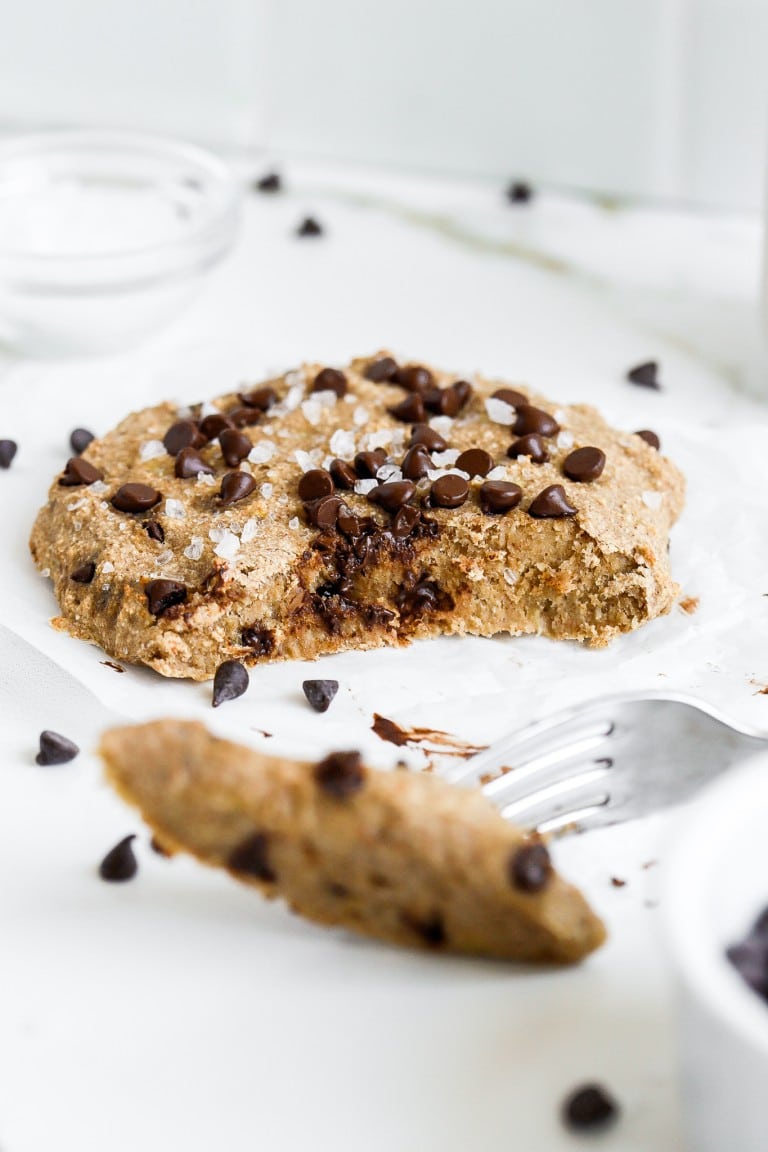 close up bite shot of chocolate chip cookie with a fork and flakey sea salt on top of cookie