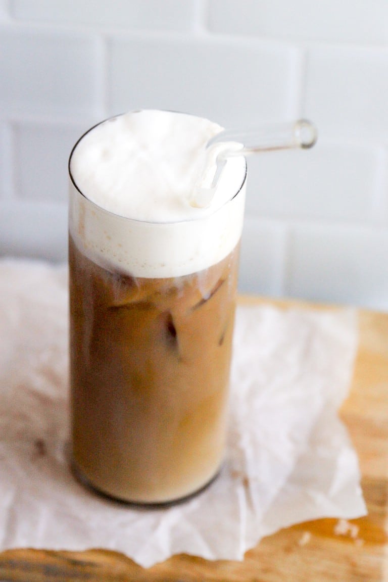 iced coffee high protein shake in a glass with a glass straw