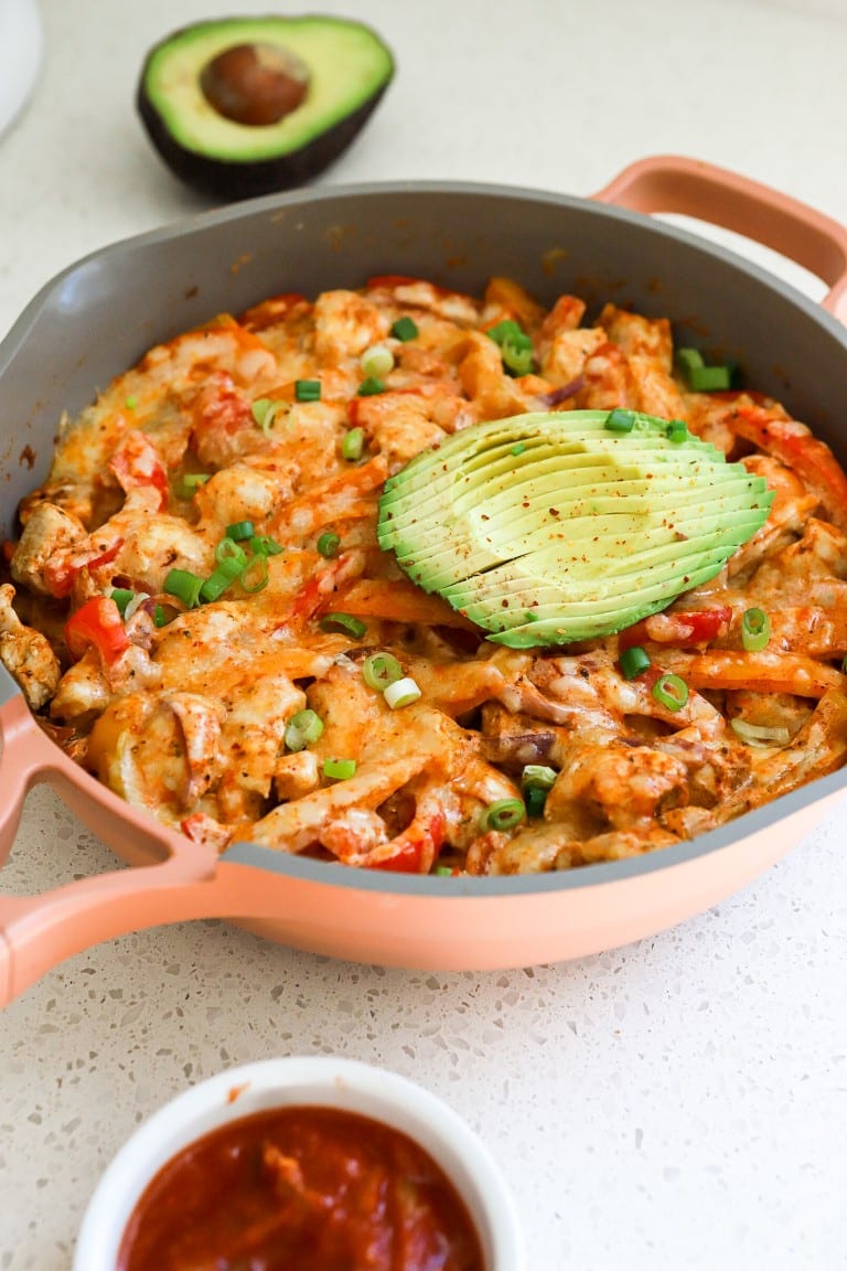 side view of keto chicken fajita casserole with green onions and avocado sliced on top