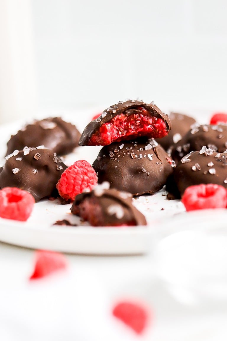 chocolate covered raspberry jam bites stacked on top of each other on white plate