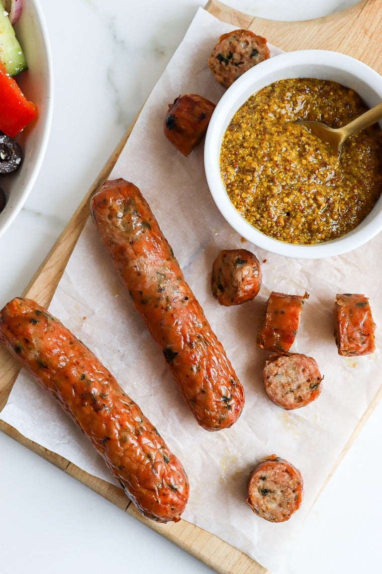 top down view of turkey sausage with a ramekin full of grainy dijon mustard