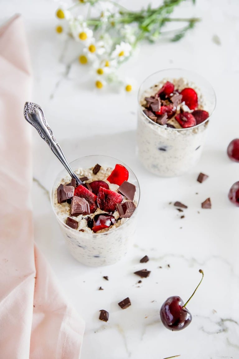 top down view of two cups of chocolate cherri overnight oats with spoon coming out