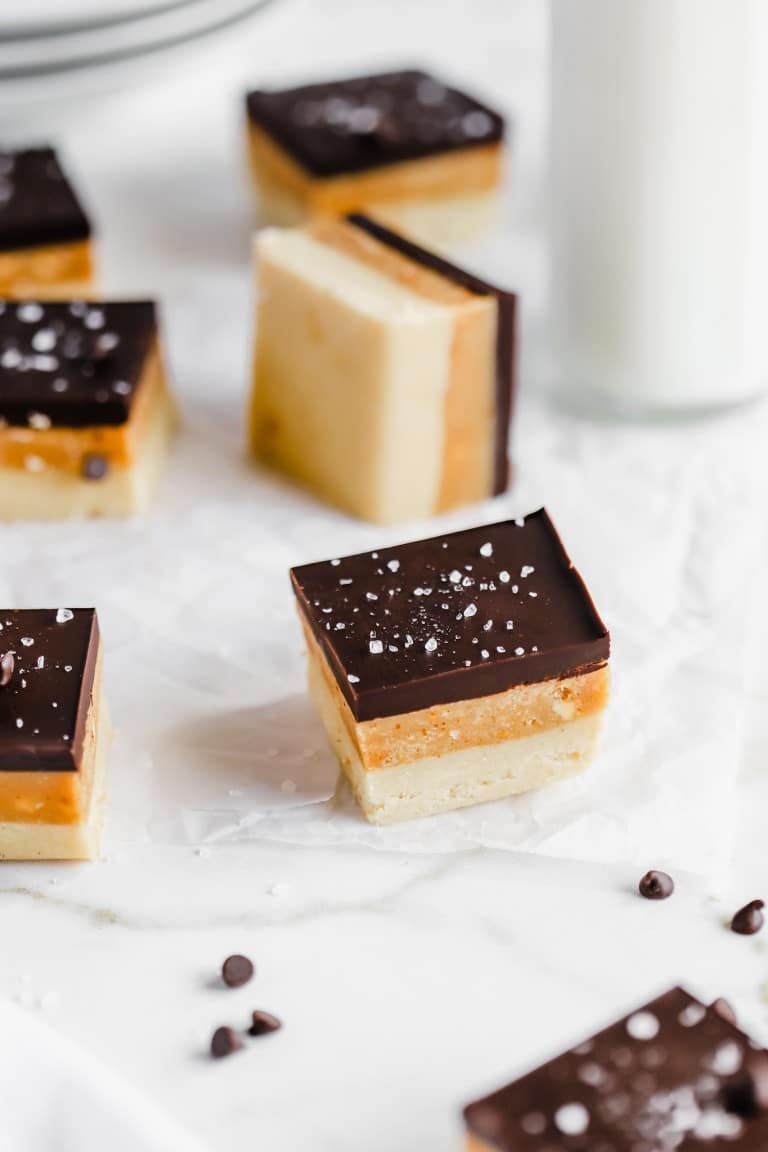 layered caramel chocolate shortbread bars on parchment paper