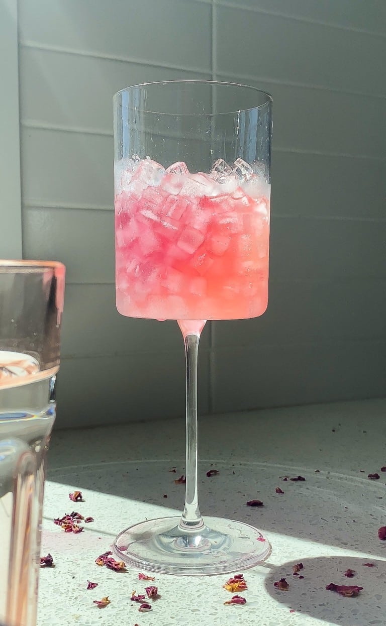 side angle of classic cocktail in square wine glass with pink gin and grapefruit juice