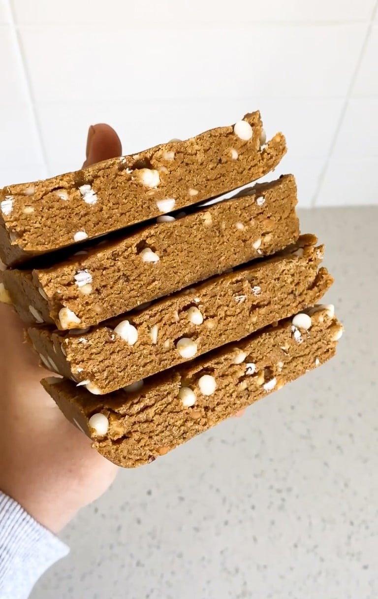 close up shot of copycat pumpkin perfect bars stacked on top of eachother in a hand