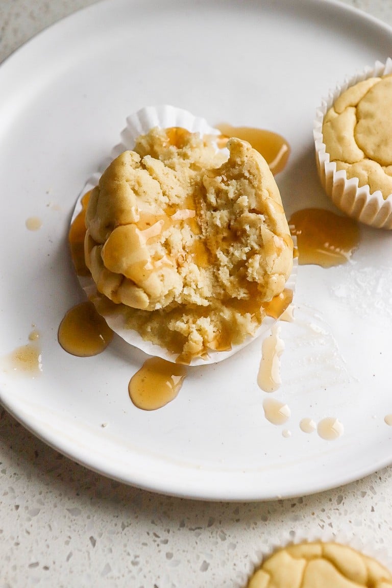 close up shot of pancake muffin cut in half with syrup drizzled all over it