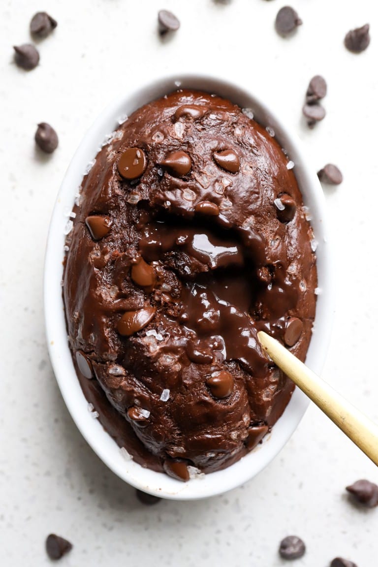 top down view of gold spoon in chocolate lava baked oats in white ramekin