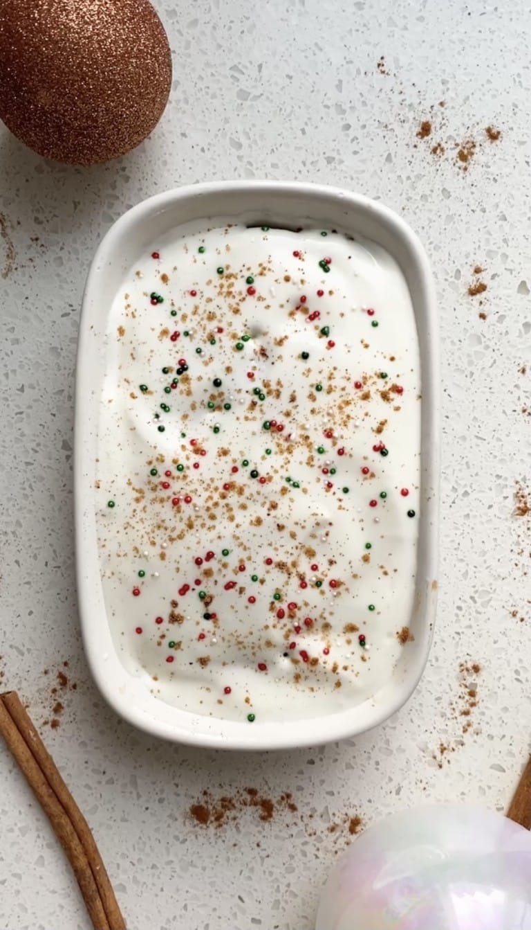 top down view of christmas morning eggnog oats with red and green sprinkles