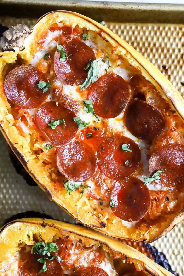 top down view of easy pizza spaghetti squash boats with pepperoni slices and basil