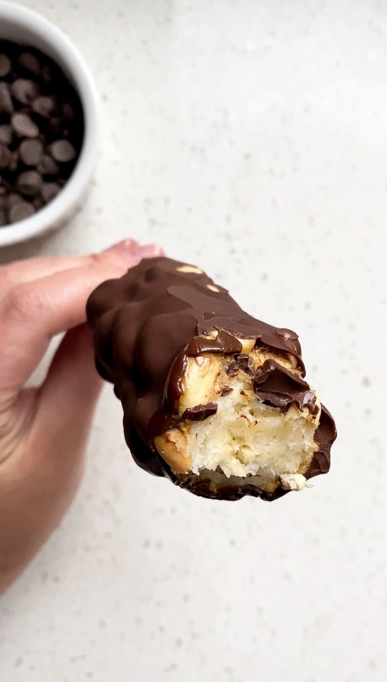 close up shot of frozen snickers banana pops with chocolate chips in background