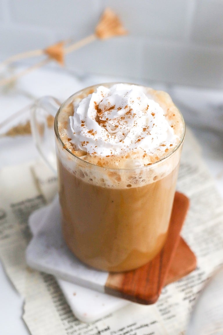 close up shot of keto pumpkin spice latte on coasters with whipped cream