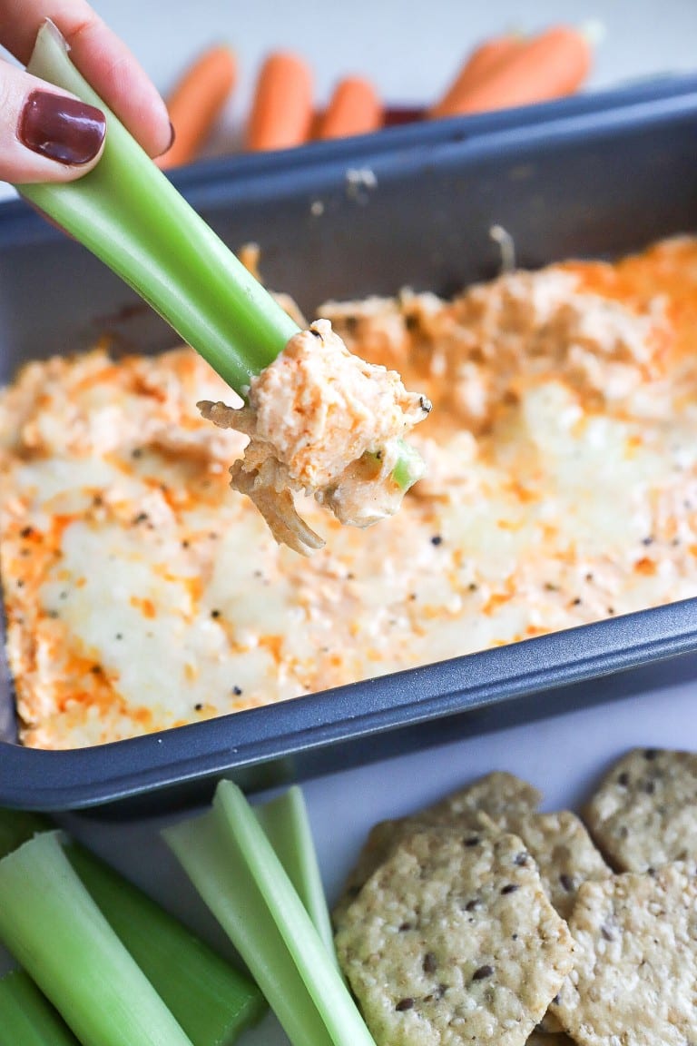 side angle of skinny buffalo dip recipe with celery dipping in