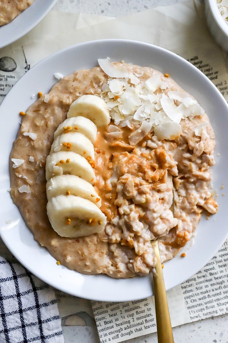 top down view of the creamiest oatmeal in white bowl with toppings