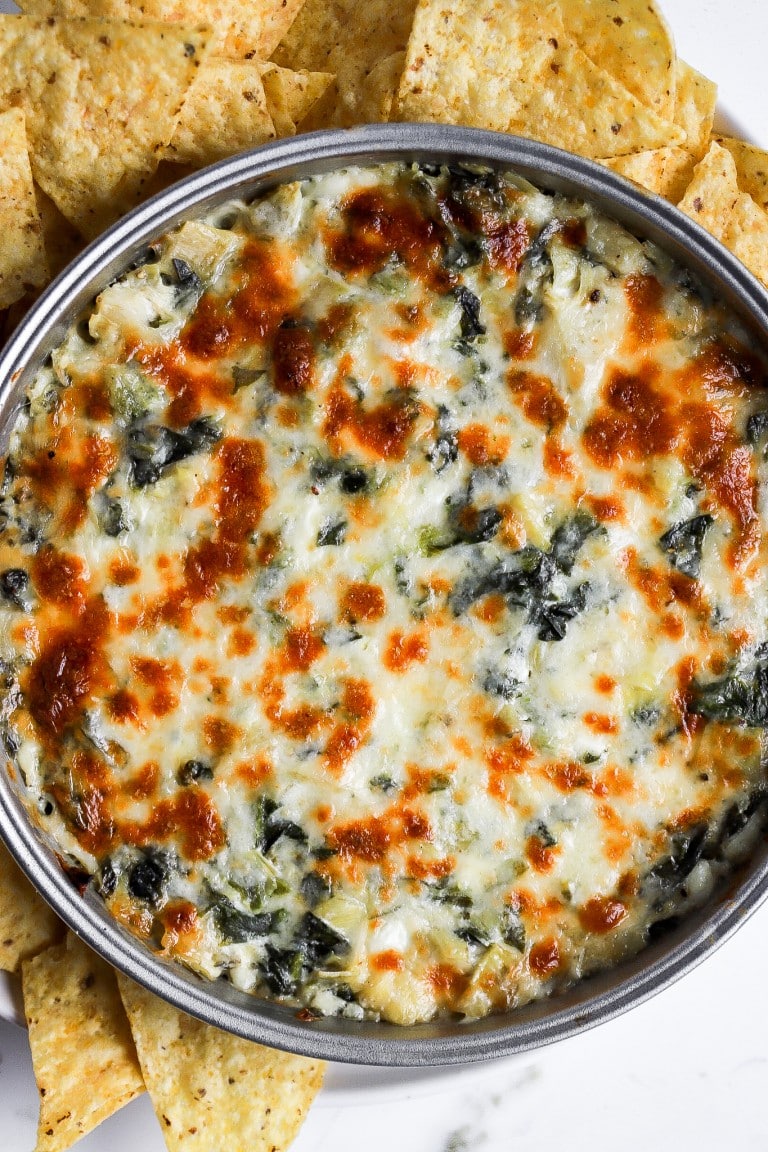 top down view of healthy spinach artichoke dip with tortilla chips