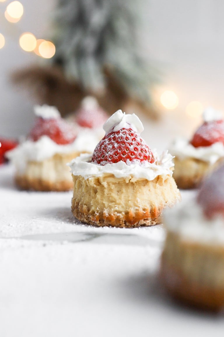 front view of strawberry santa hats for christmas with christmas tree in background