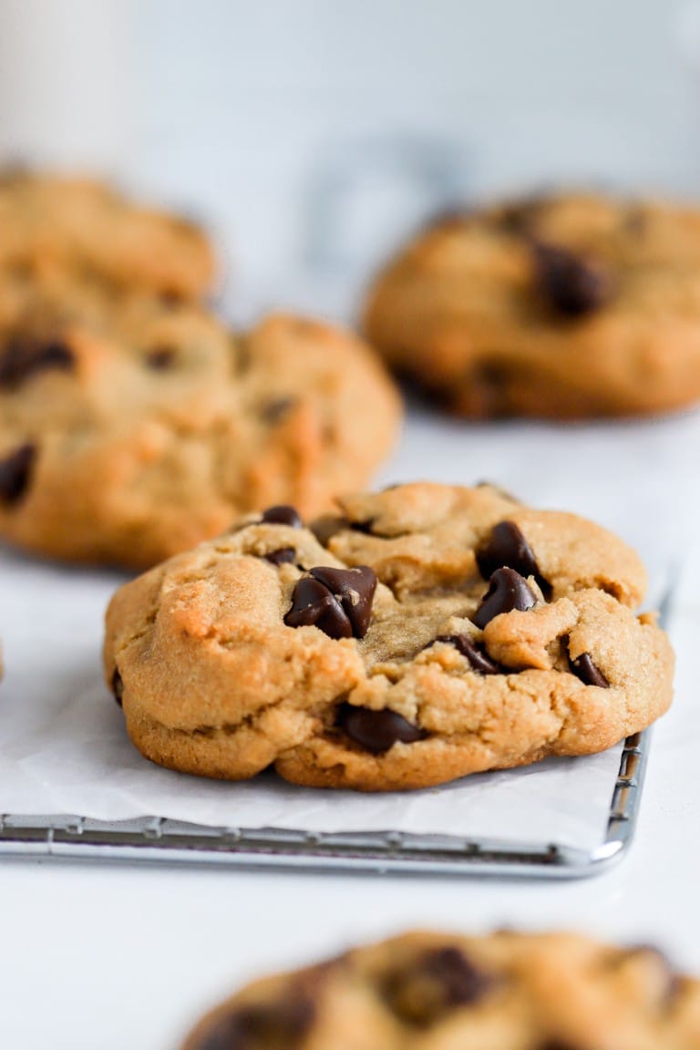 close up shot of the best chocolate chip cookies on cooling rack with parchment paper