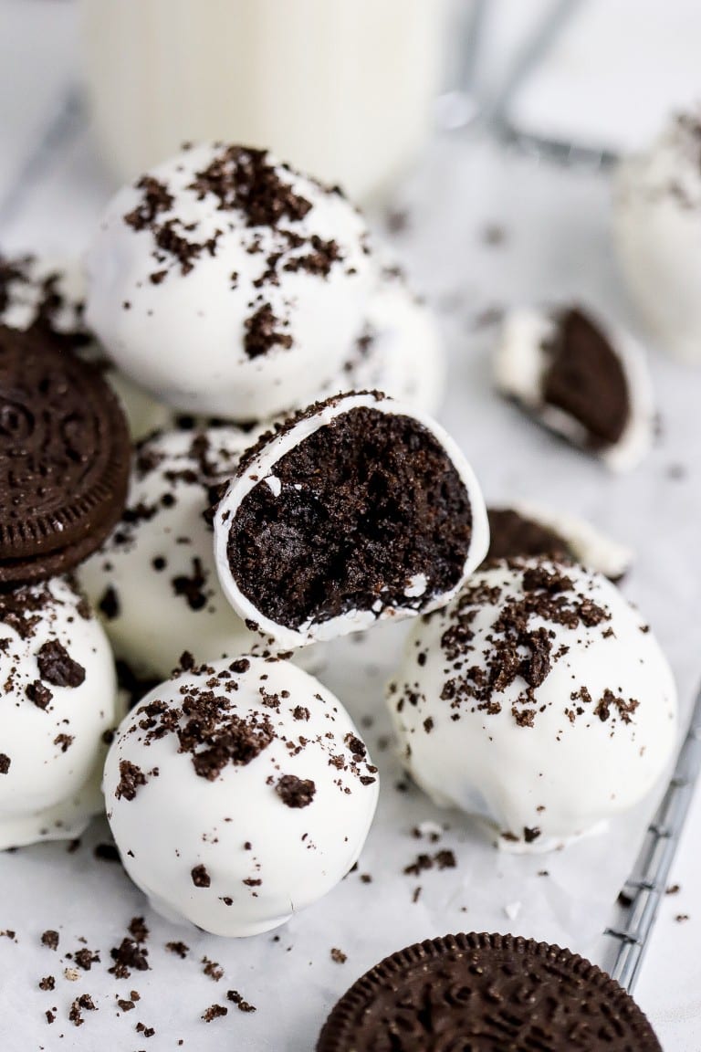 a bunch of gluten-free oreos with cream cheese stacked on top of each other on a cooling rack