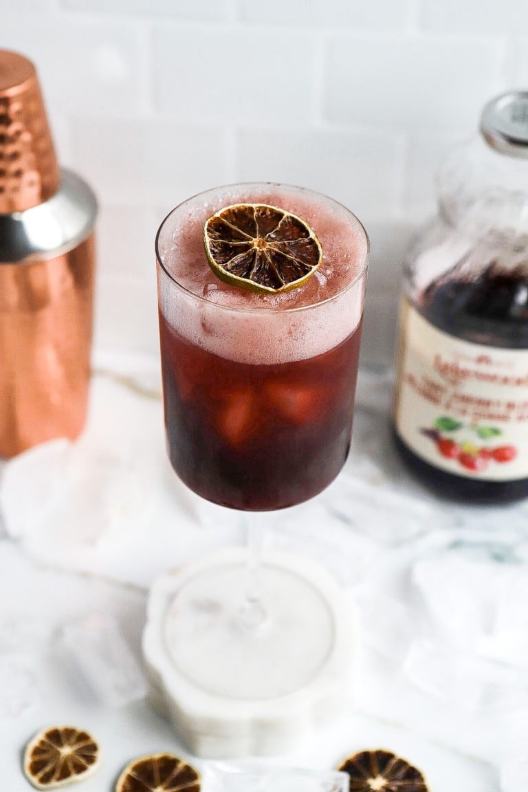 cherry magnesium sleep drink in wine glass with dried lime on top