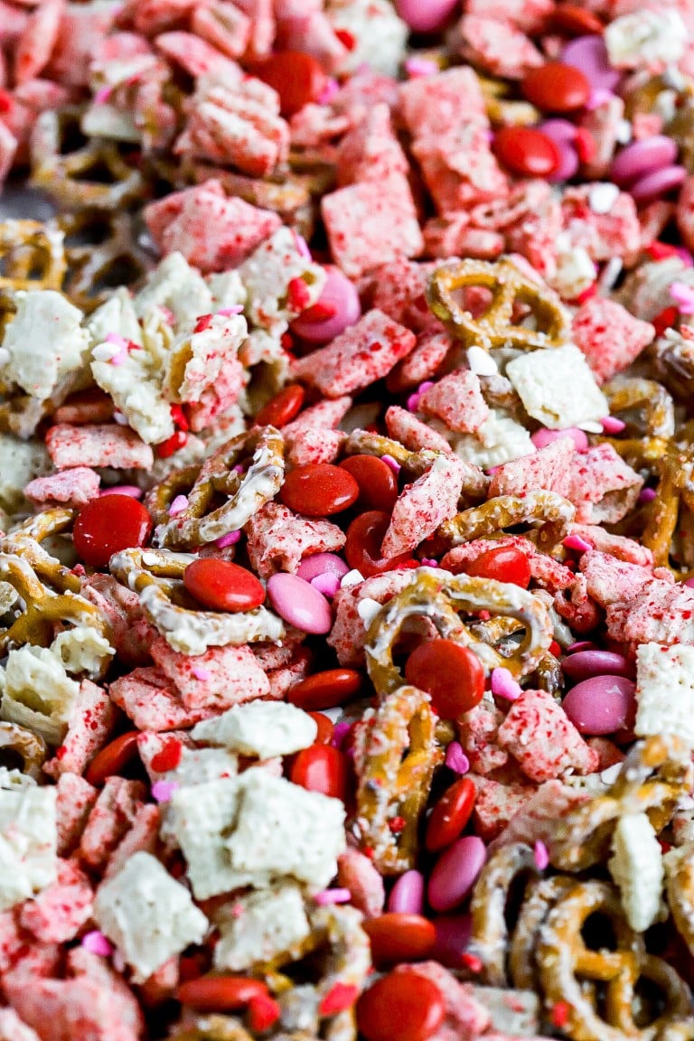 close up view of easy muddy buddies recipe with red and pink smarties