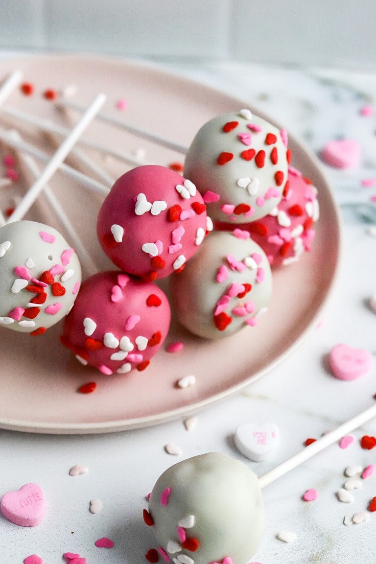 shot of pink and white valentines day cake pops on white plate