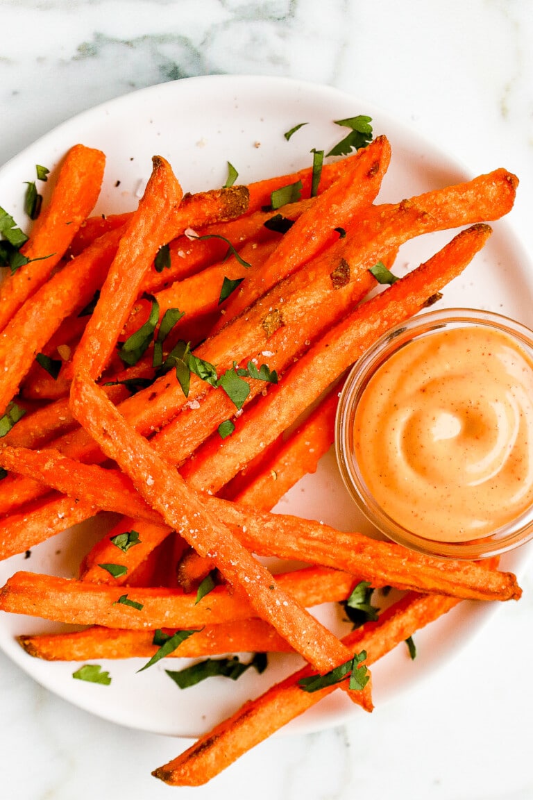 top down close up shot of frozen sweet potato fries on white plate with chipotle mayo