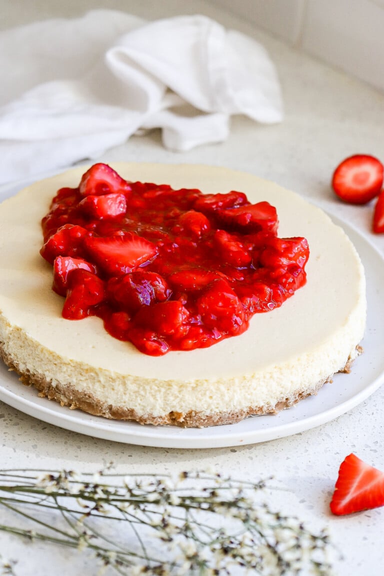 side view of gluten free strawberry cheesecake with fresh strawberries on top