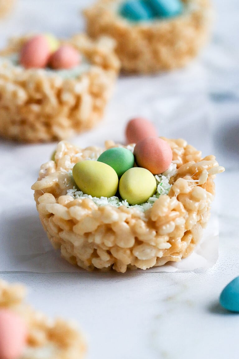 side view of Rice Krispie nests with mini eggs in the middle and green coconut for the grass