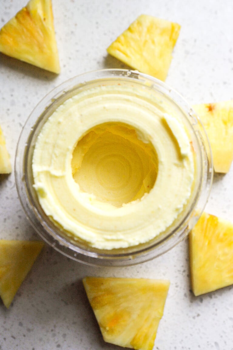 Top down view of creamy pineapple sorbet in Ninja Creami container.