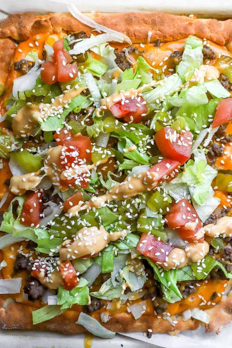 Top down view of protein Big Mac pizza with fresh toppings.