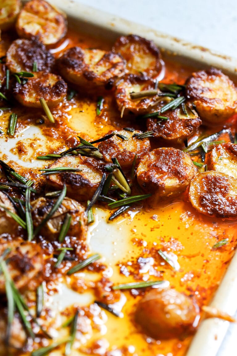 Side view of garlic parmesan air fryer potatoes with fresh rosemary.