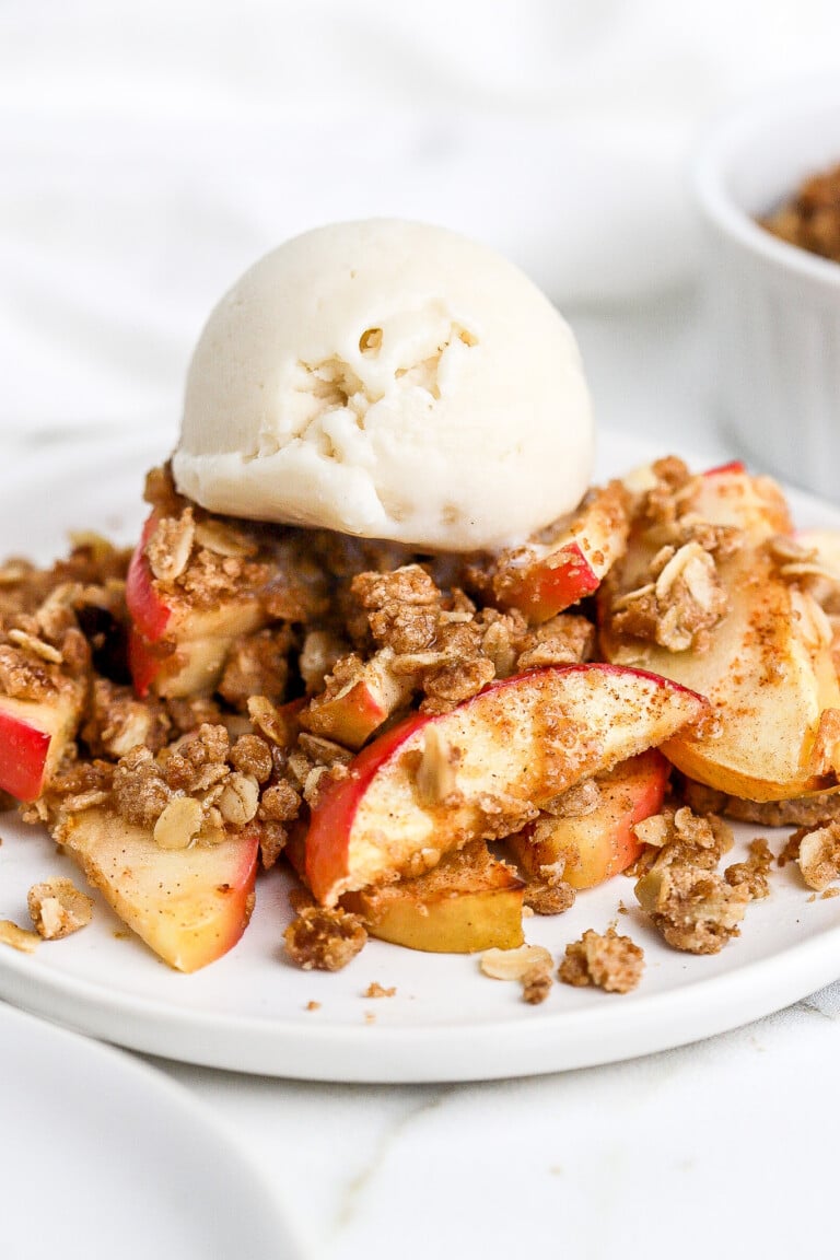 Close up shot of air fryer apple crumble with scoop of ice cream.