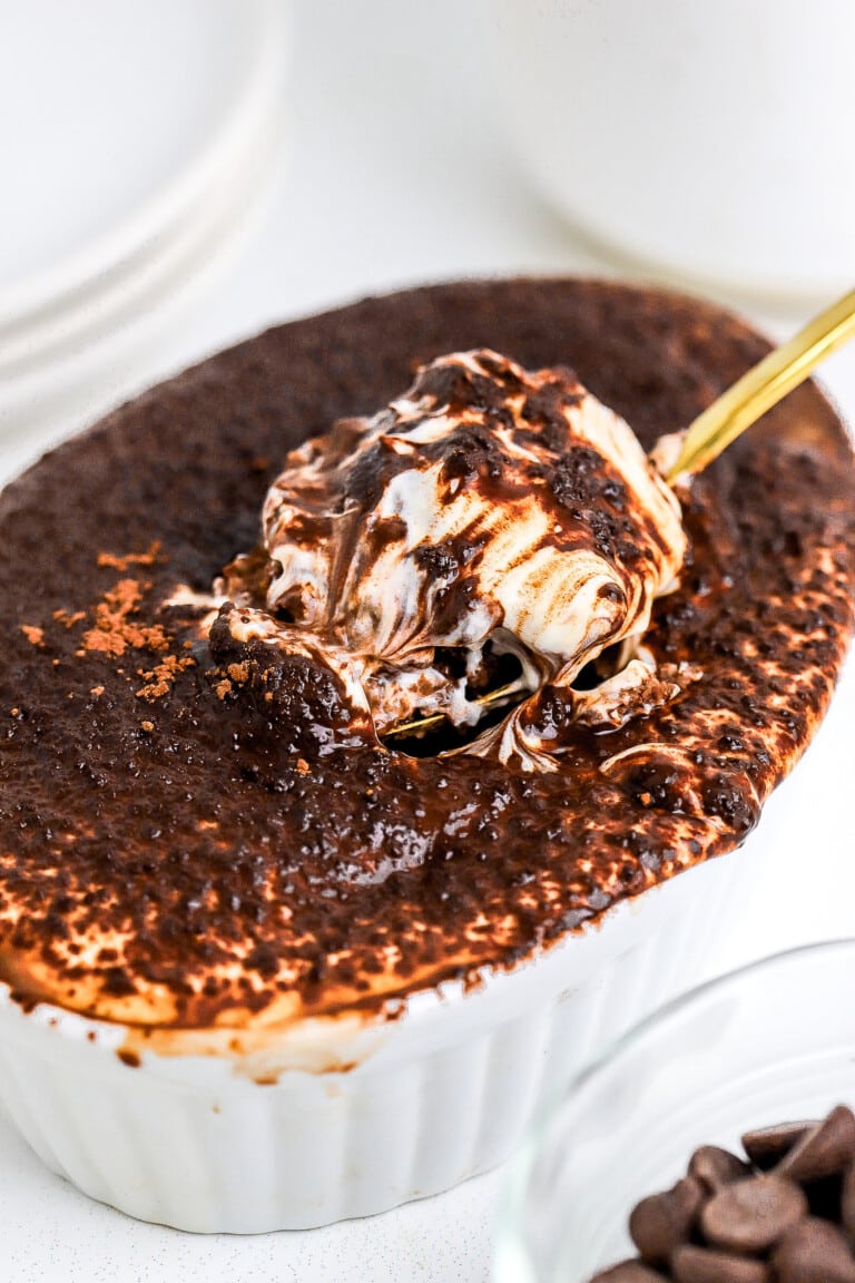 A spoonful of chocolate yogurt and oats in white ramekin.