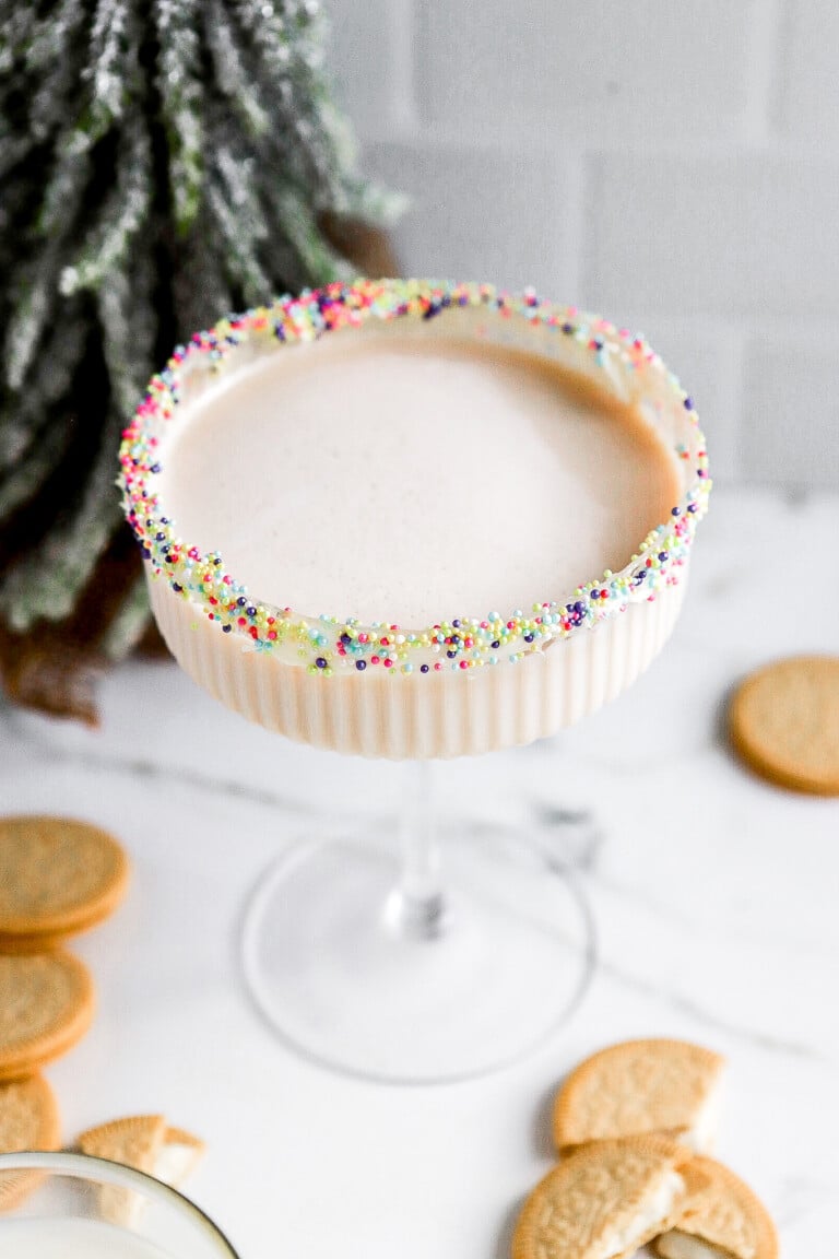 Side view of festive holiday sugar cookie cocktail in coupe glass.