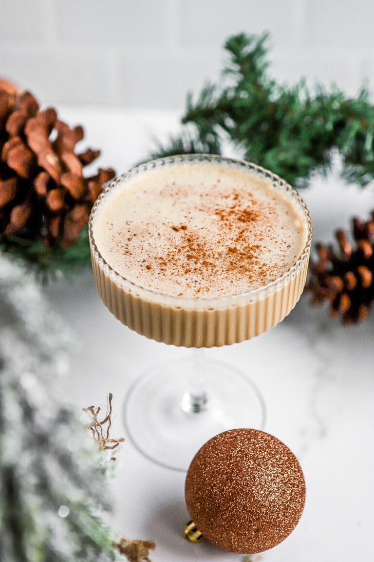 Side view of homemade eggnog espresso recipe with garland in background.