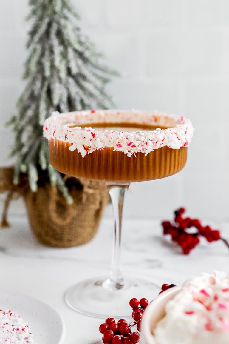 Front facing view of peppermint mocha espresso martini with christmas tree in background.