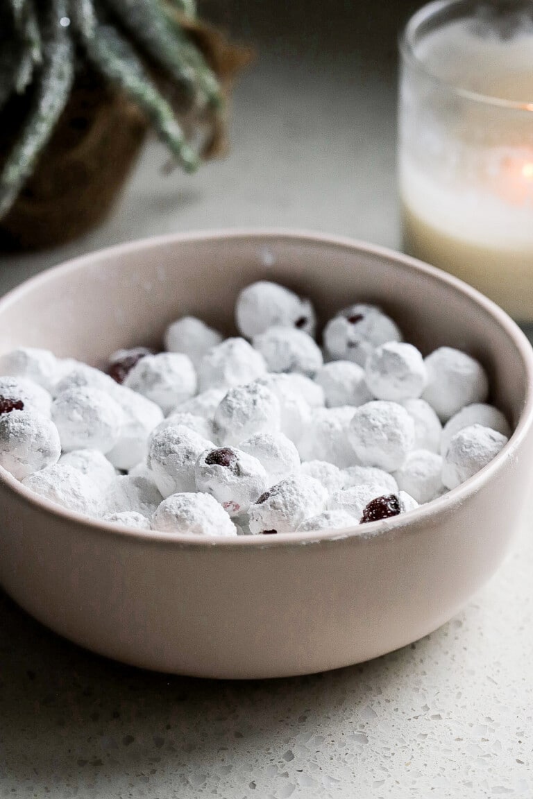 Bowl of the viral candied cranberries in a small pink bowl with candle in background.