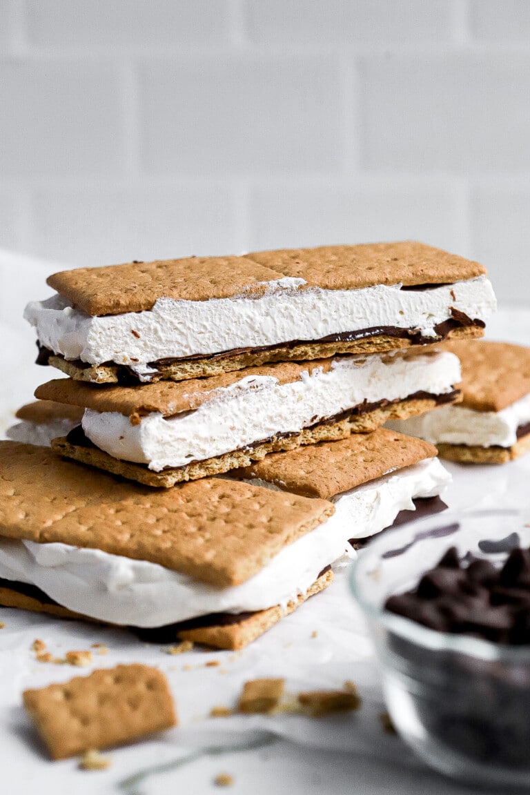 Front facing view of easy frozen protein s'mores stacked on top of one another with chocolate chips in foreground.