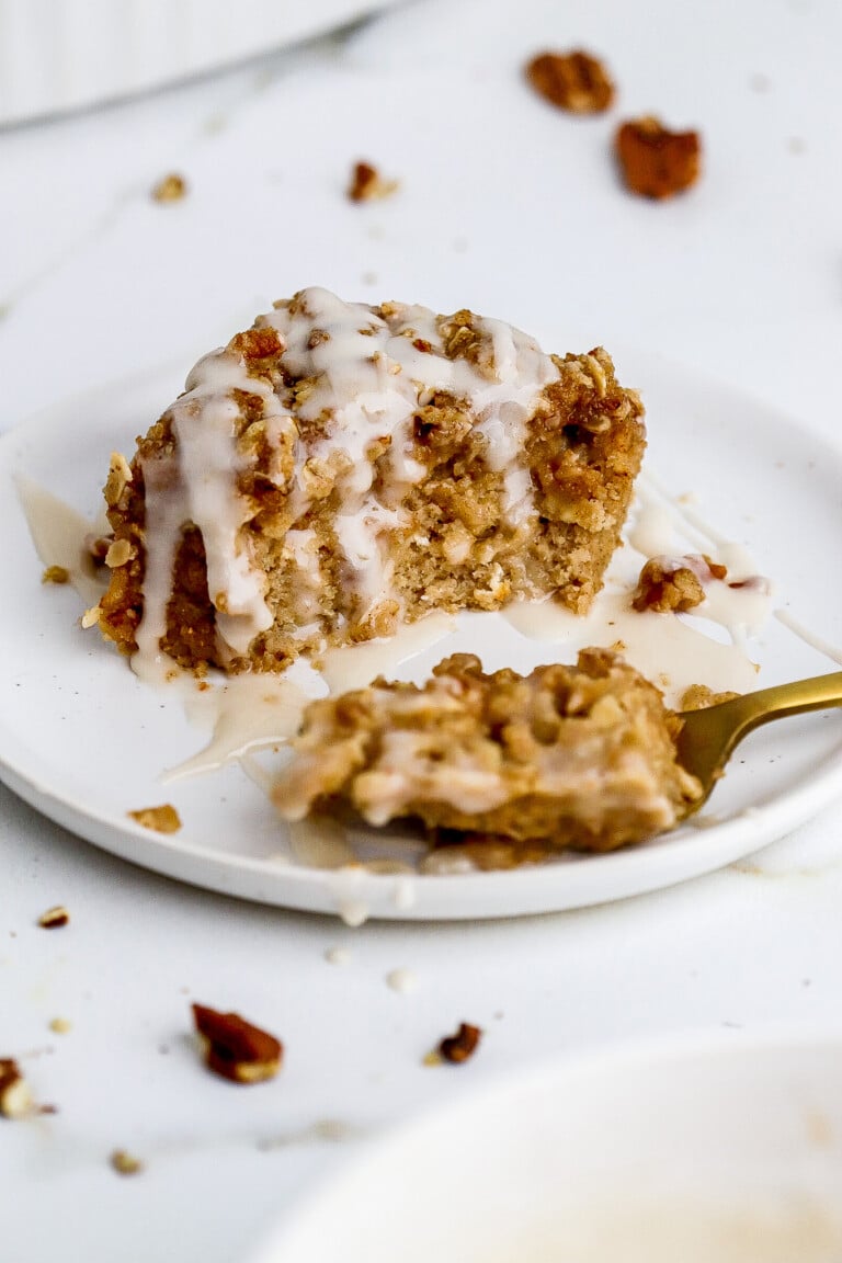 Close up shot of protein coffee cake baked oats on white plate with gold fork.