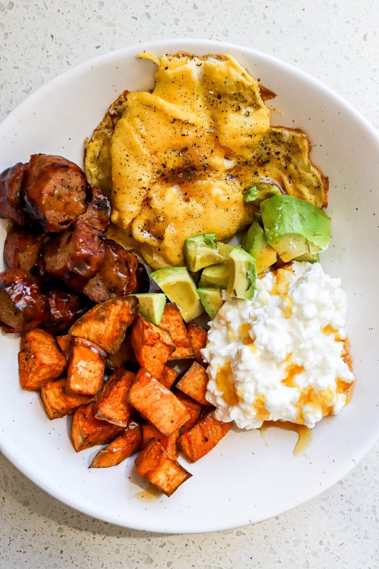 Close up view of a sweet potato breakfast bowl with fluffy scrambled eggs.