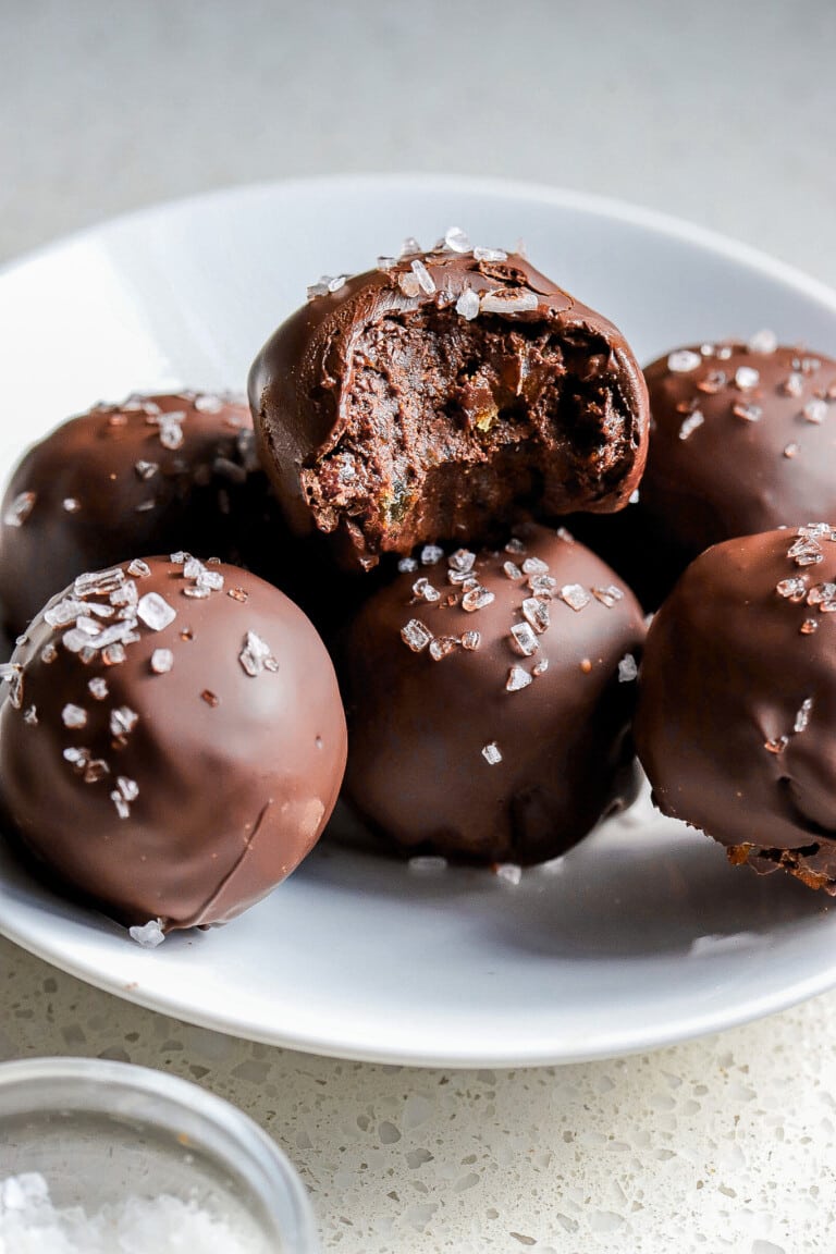 Front view of viral brownie balls on white plate with coarse salt.