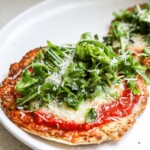 Chicken parmesan smash tacos topped with marinara, mozzarella, basil, and arugula