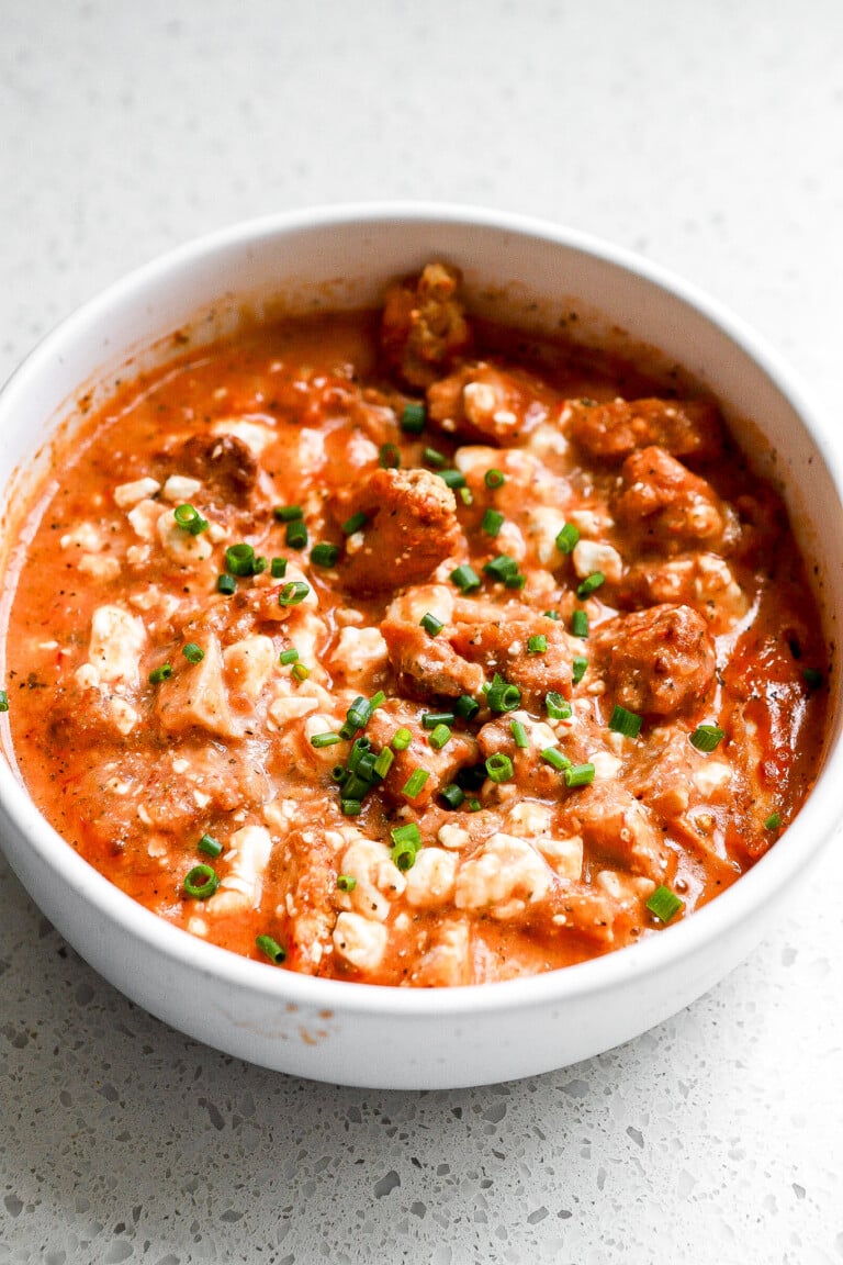 Side angle of a cottage cheese chicken parm bowl with chives on top.
